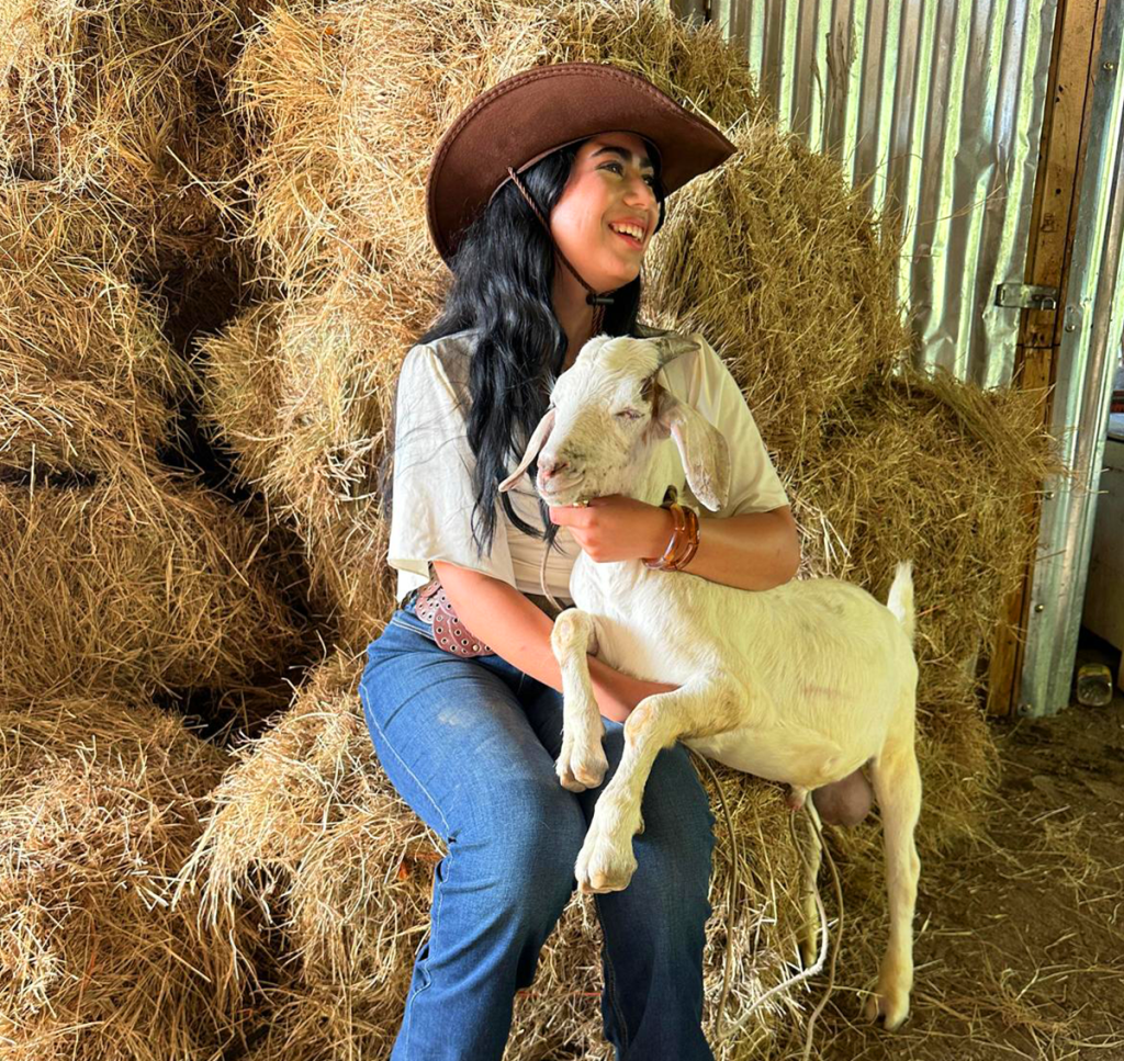 Woman smiling while hold a goat