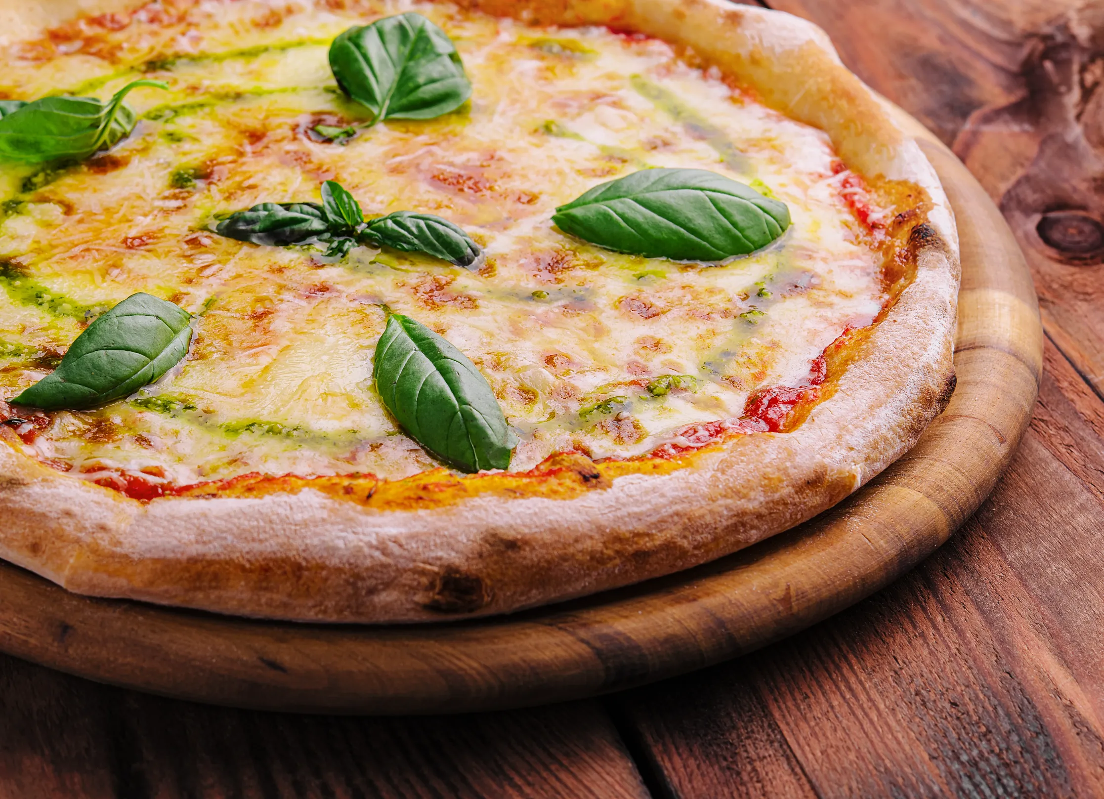 Pizza with melted mozzarella cheese and fresh basil.